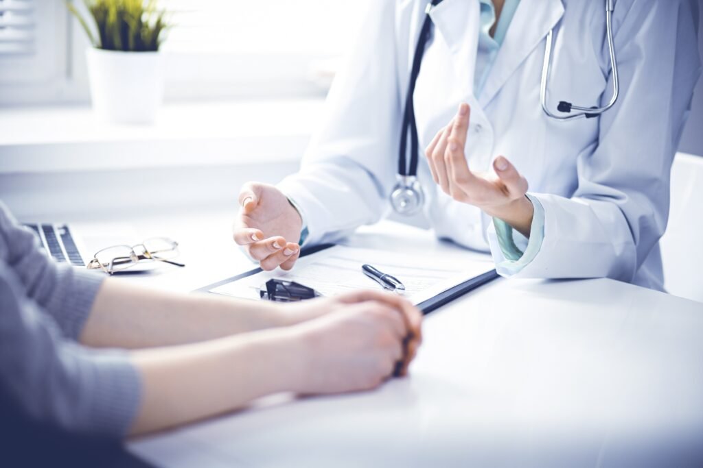 Close-up of a doctor discussing medical information with a patient across a desk.