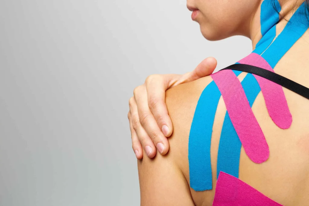 person with colorful kinesiology tape applied to their shoulder for support and pain relief.
